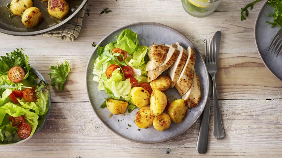 Gebakken bouillon aardappels met gebakken kipfilet en salade